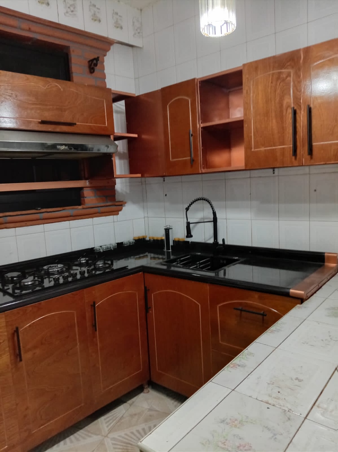 Cocina integral con acabado madera y cubierta negra